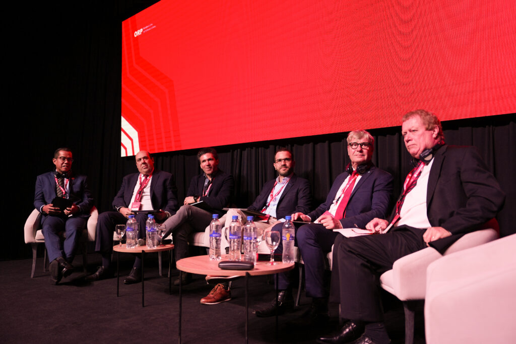 Mesa de debate con seis participantes en el escenario del congreso